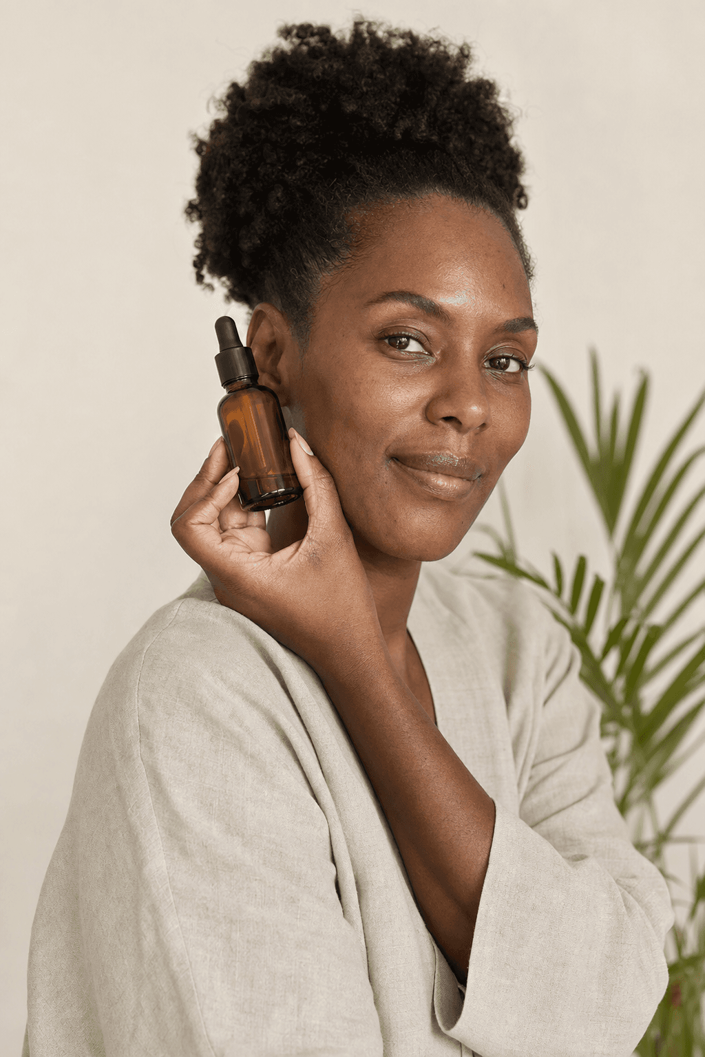 Muhé Afro-Karibense ku tono di piel profundo ku un serum di kuido di piel.
